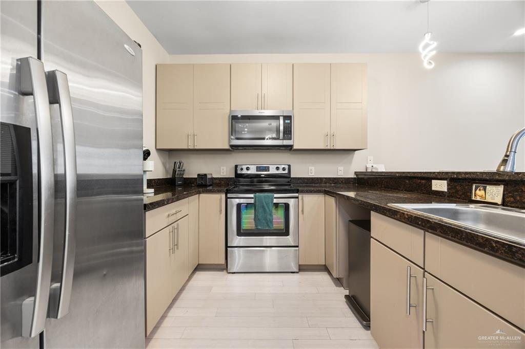 813 Travis Street, Unit 315 Mission, TX 78572 - Photo 9 of 25 a kitchen with a refrigerator and a sink
