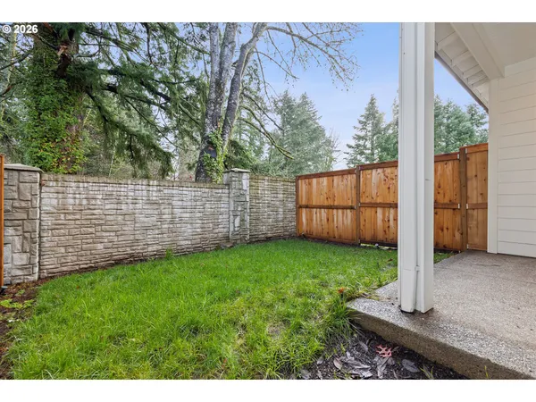 a view of a backyard with wooden fence
