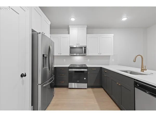 a kitchen with stainless steel appliances granite countertop a refrigerator sink and stove