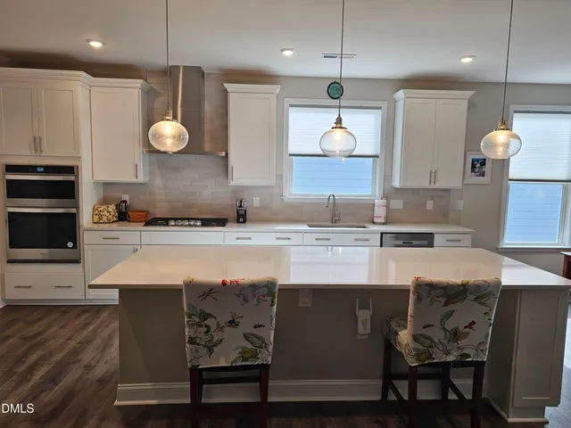 a kitchen with stainless steel appliances granite countertop a sink and a refrigerator