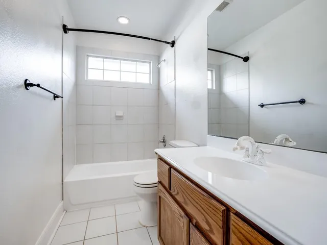 a bathroom with a bathtub shower sink vanity and toilet