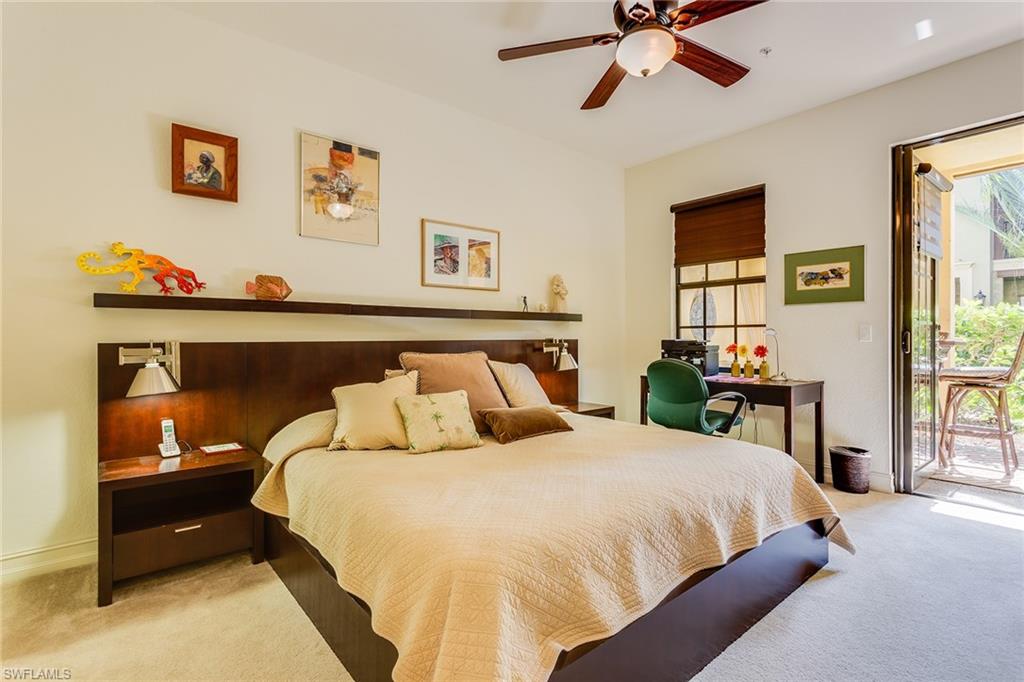 9088 Chula Vista Street, Unit 1083 Naples, FL 34113 - Photo 13 of 31 a bedroom with a bed and a chandelier