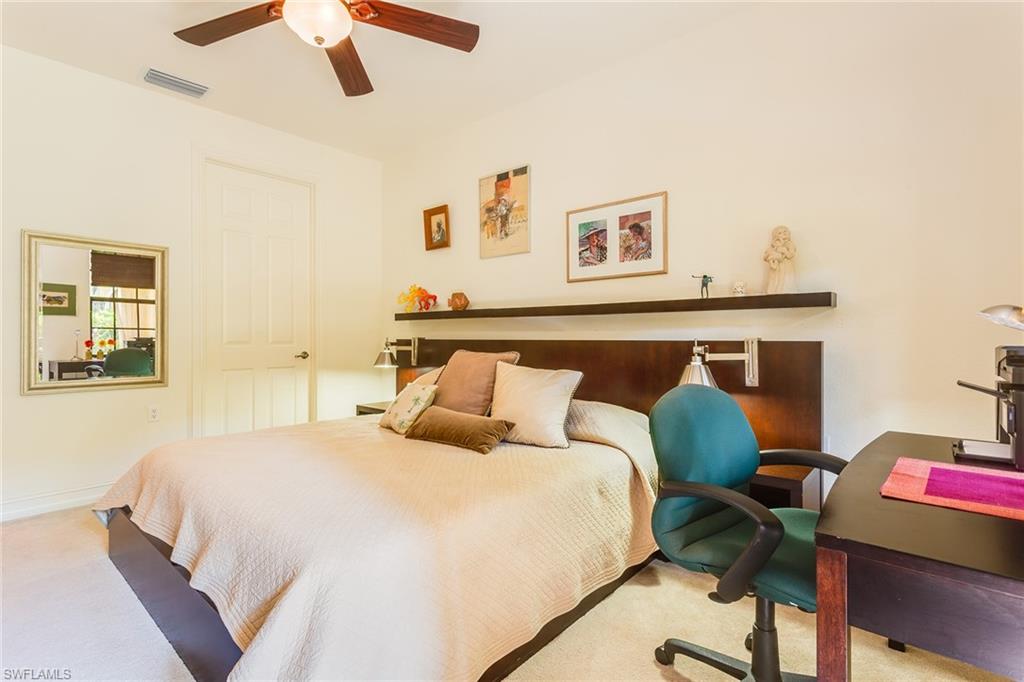9088 Chula Vista Street, Unit 1083 Naples, FL 34113 - Photo 15 of 31 a bedroom with a bed and a table with potted plant