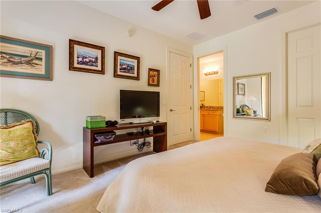 9088 Chula Vista Street, Unit 1083 Naples, FL 34113 - Photo 16 of 31 a bedroom with a bed and a flat screen tv