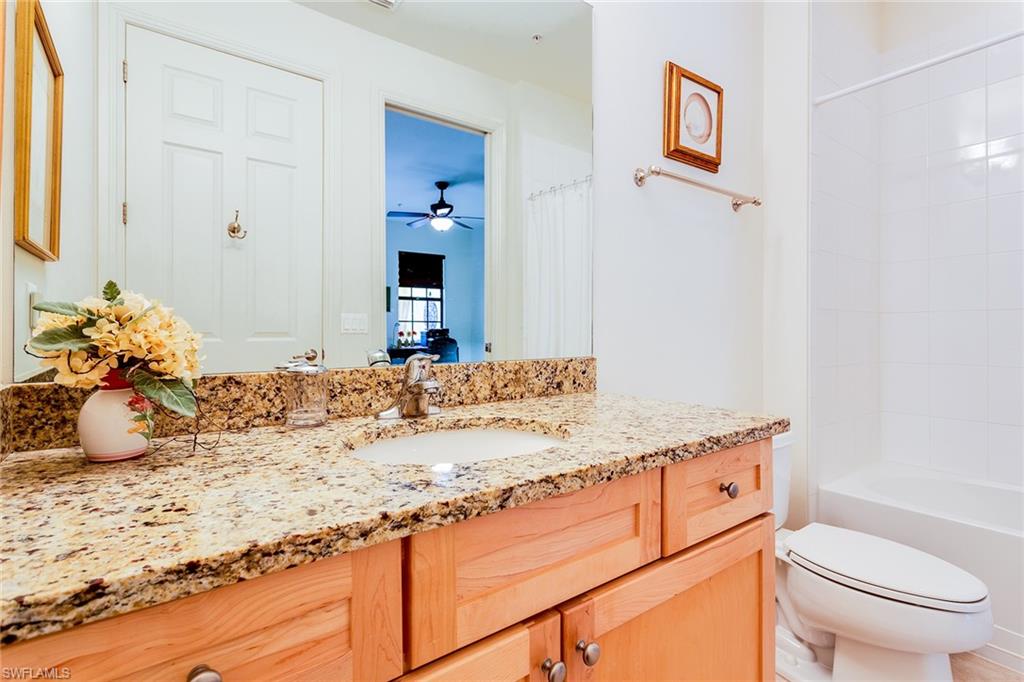 9088 Chula Vista Street, Unit 1083 Naples, FL 34113 - Photo 20 of 31 a bathroom with a granite countertop sink and a mirror