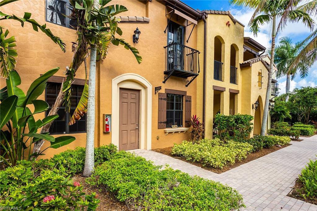 9088 Chula Vista Street, Unit 1083 Naples, FL 34113 - Photo 2 of 31 front view of a house with a yard