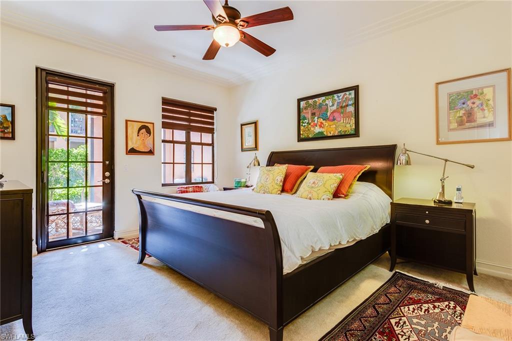 9088 Chula Vista Street, Unit 1083 Naples, FL 34113 - Photo 21 of 31 a bedroom with a bed and glass window