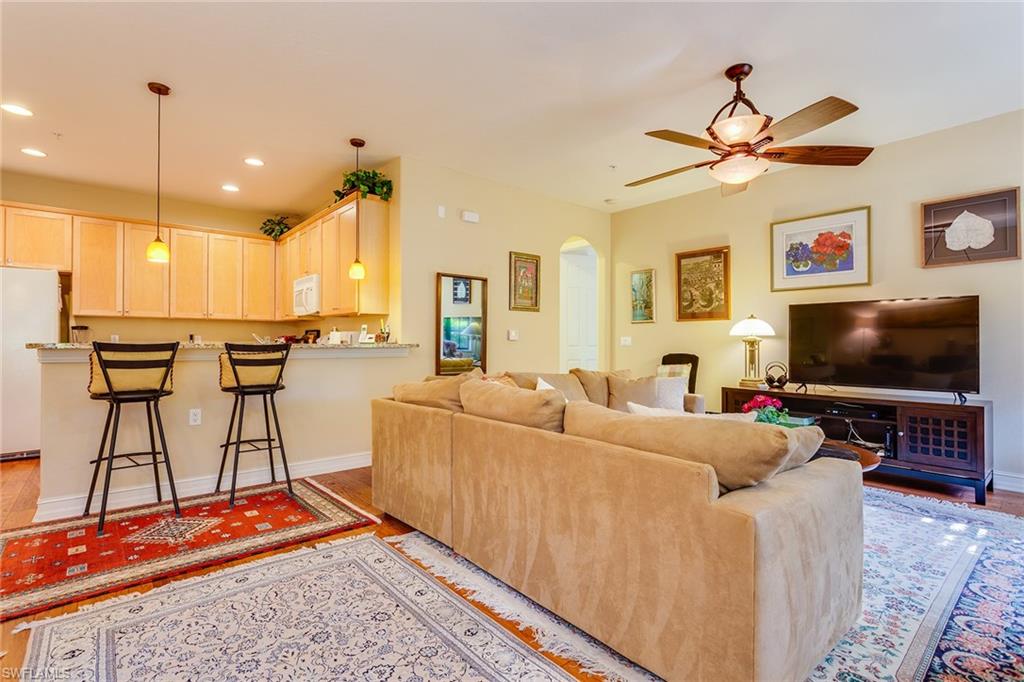 9088 Chula Vista Street, Unit 1083 Naples, FL 34113 - Photo 5 of 31 a living room with furniture and a flat screen tv