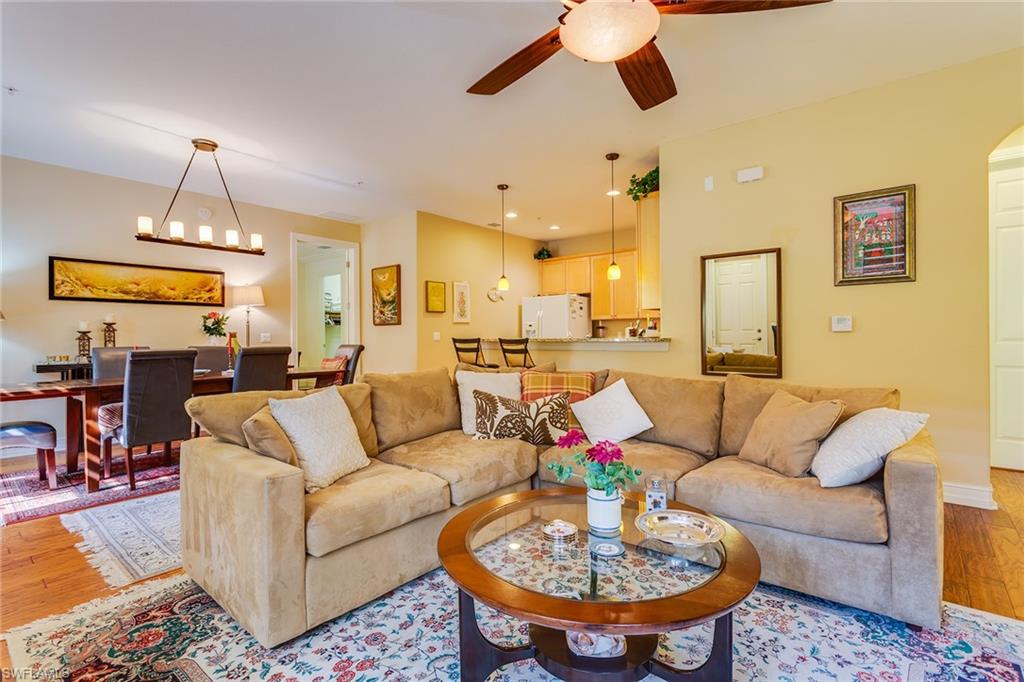 9088 Chula Vista Street, Unit 1083 Naples, FL 34113 - Photo 7 of 31 a living room with furniture kitchen view and a chandelier
