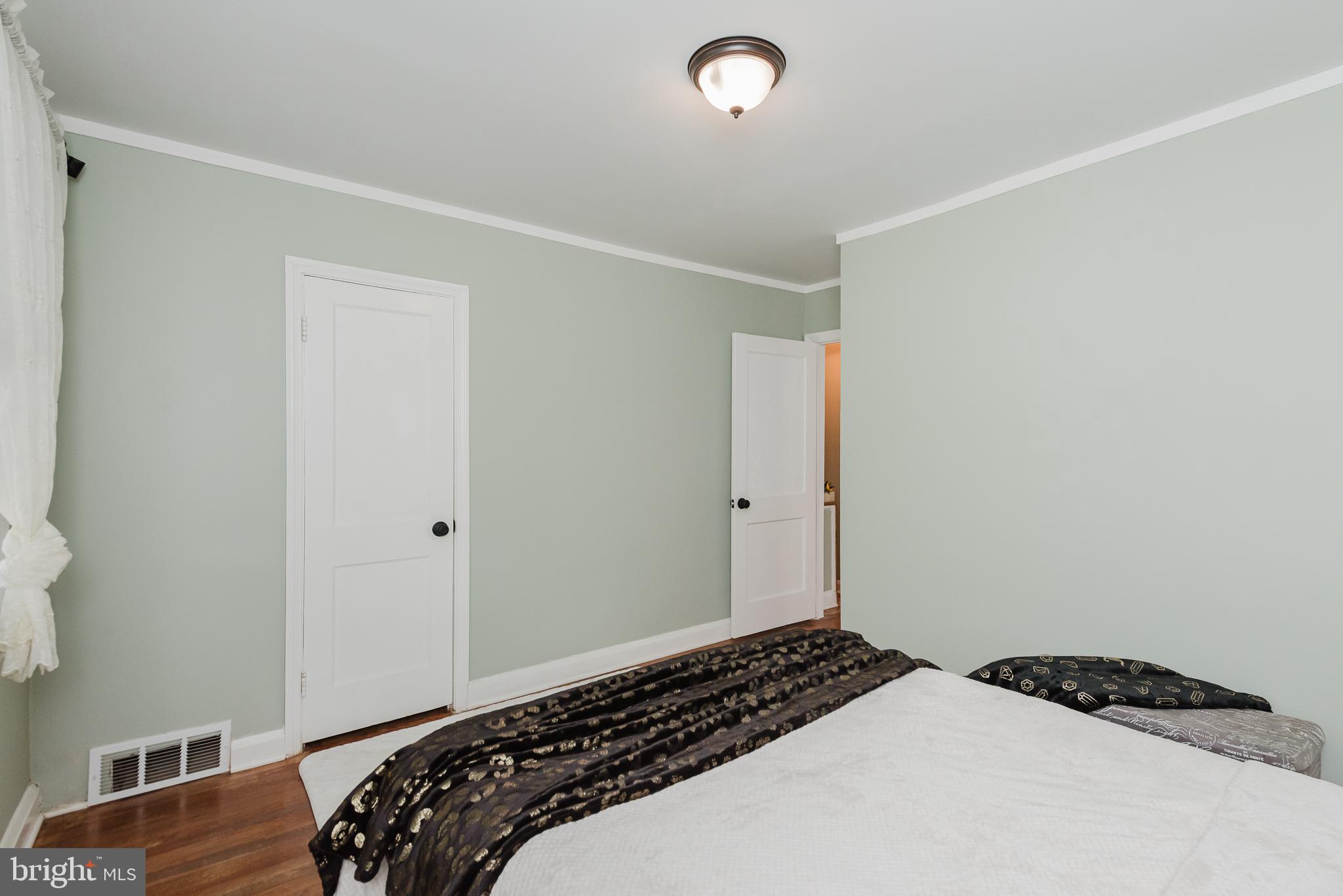 570 47th Street Baltimore, MD 21224 - Photo 18 of 41 a bedroom with a bed and wooden floor