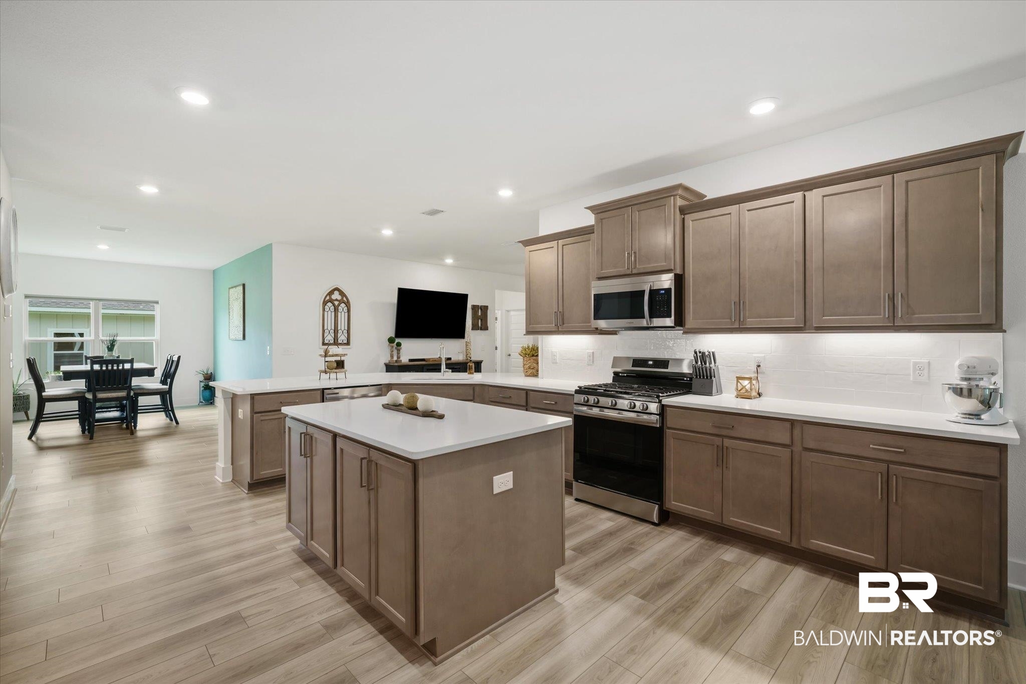 263 Bronze Street Fairhope, AL 36532 - Photo 11 of 47 Kitchen featuring backsplash, light wood-type flooring, appliances with stainless steel finishes, and kitchen peninsula