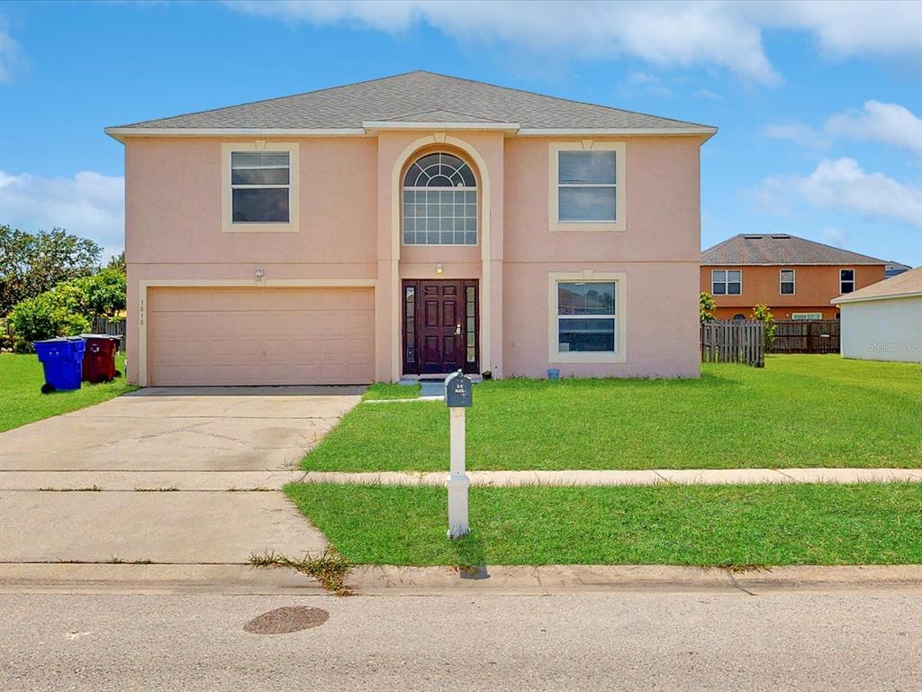 a front view of a house with a yard and garage