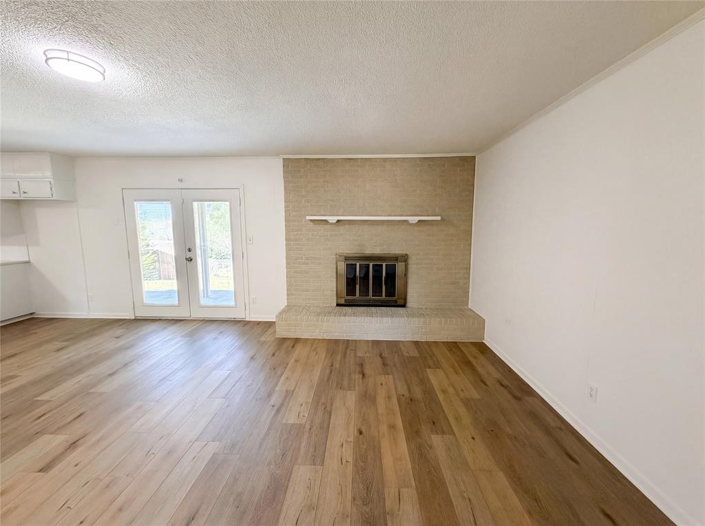 607 State Street Weatherford, TX 76086 - Photo 3 of 16 a view of empty room with a fireplace and wooden floor