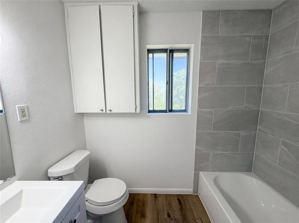 607 State Street Weatherford, TX 76086 - Photo 10 of 16 a bathroom with a toilet a sink and bathtub