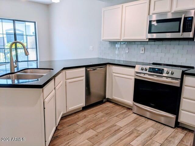 3150 East Beardsley Road, Unit 1045 Phoenix, AZ 85050 - Photo 4 of 23 a kitchen with granite countertop a stove a microwave a sink and cabinets
