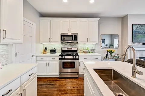 a kitchen with cabinets stainless steel appliances a sink and a stove