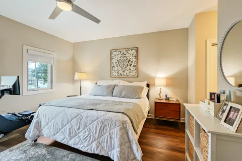 a bedroom with a bed and a large mirror on the dresser