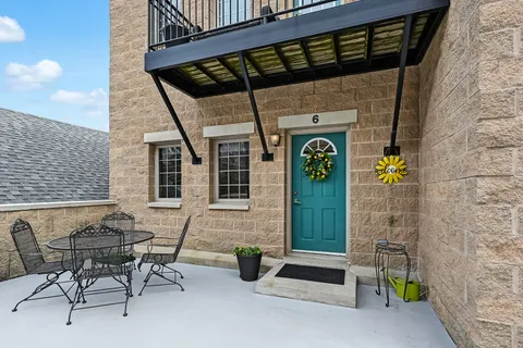 a view of entrance door of house with outdoor seating