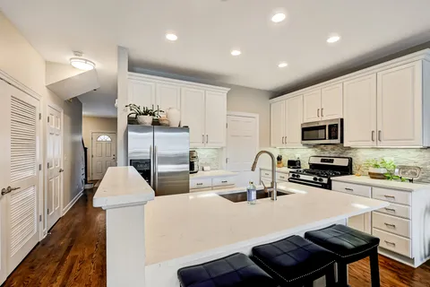a kitchen with sink a microwave and cabinets