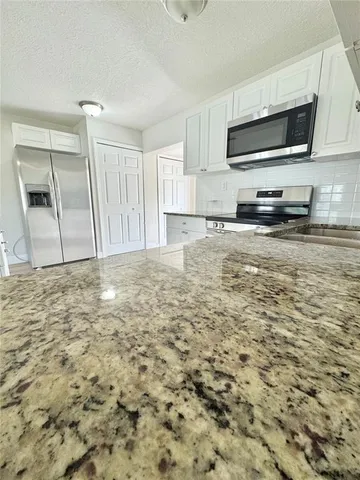 a view of kitchen with sink and microwave
