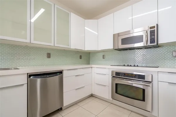 a kitchen with cabinets stainless steel appliances and sink