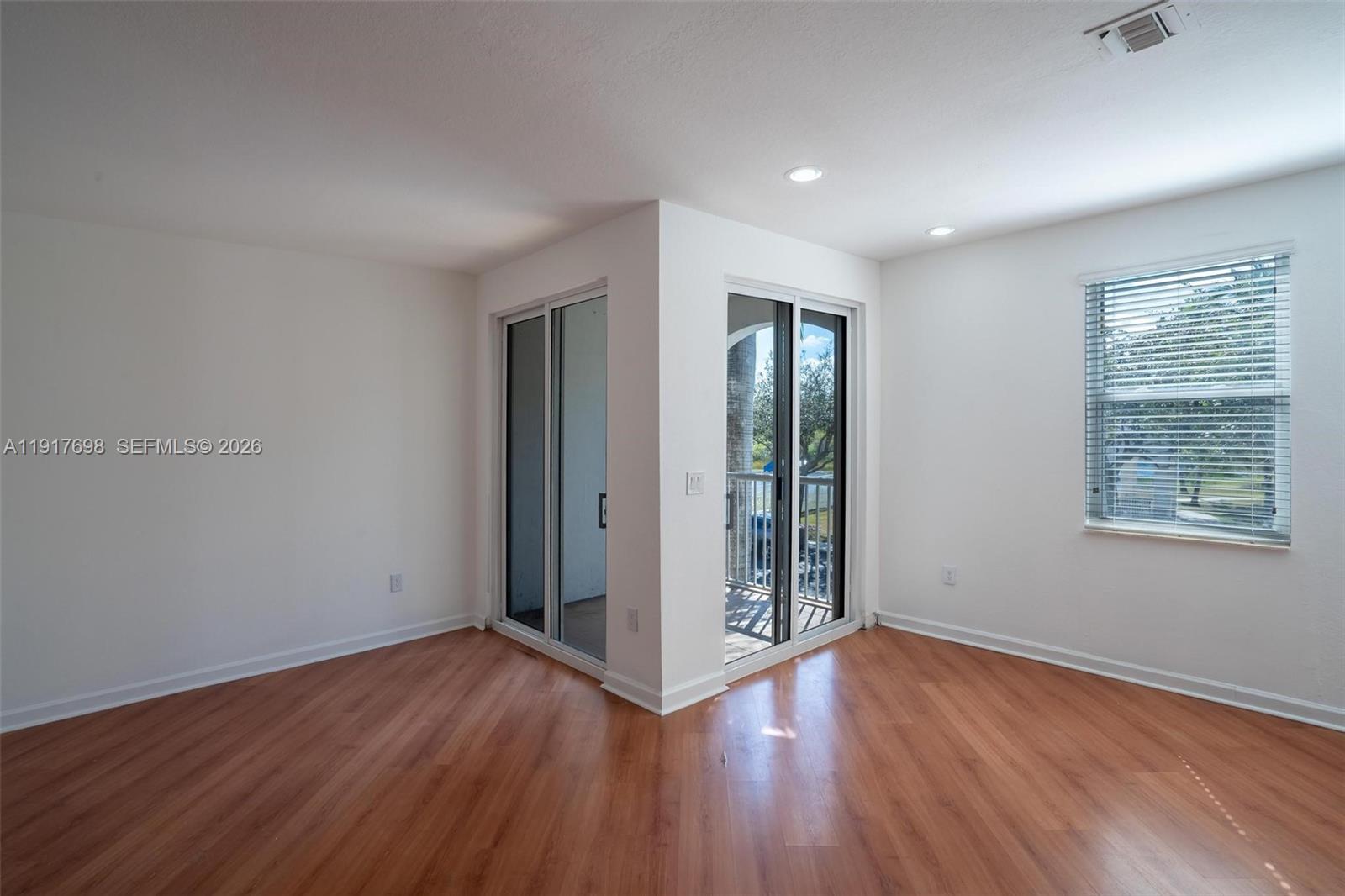 4371 Southwest 160th Avenue, Unit 211 Miramar, FL 33027 - Photo 4 of 31 an empty room with wooden floor and windows