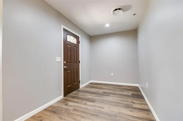 a view of empty room with wooden floor