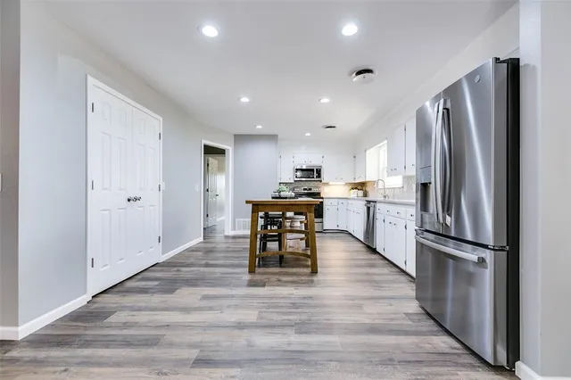 a kitchen with stainless steel appliances granite countertop a refrigerator stove microwave and cabinets