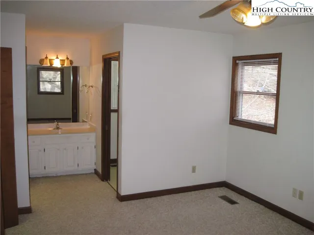 an empty room with a mirror and dresser