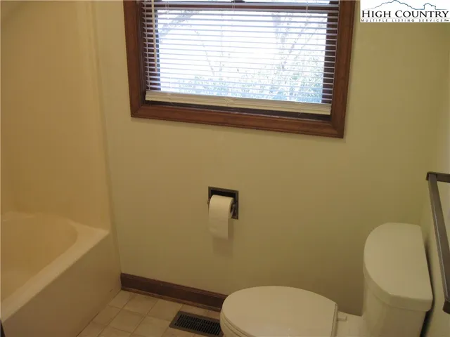 a white toilet sitting next to a bath tub