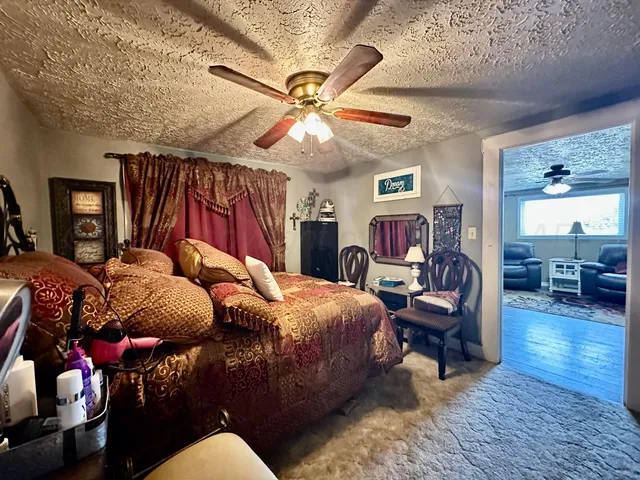 a bedroom with a bed wooden floor and ceiling fan