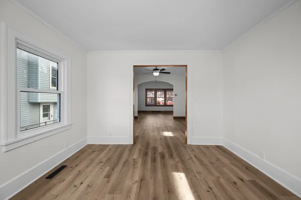 an empty room with wooden floor and windows