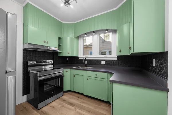 a kitchen with a sink a stove and cabinets