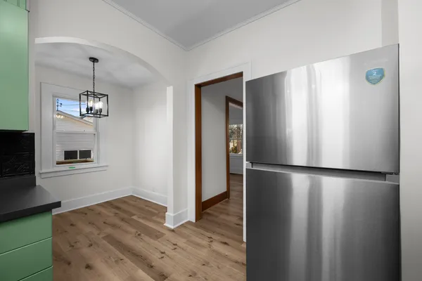 a view of kitchen with refrigerator cabinets and wooden floor