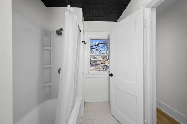 a bathroom with a shower and a door