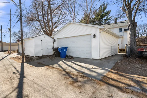 a view of a white house with a large tree