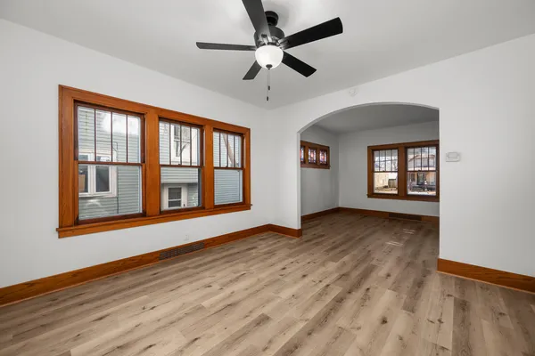 a view of an empty room with window and wooden floor