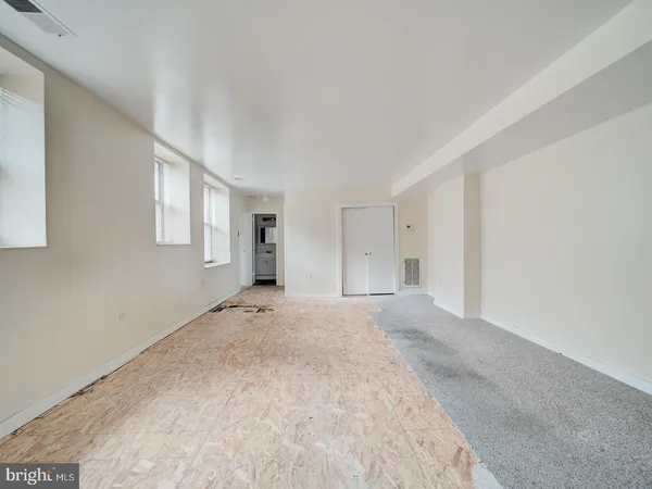a view of a big room with closet and windows