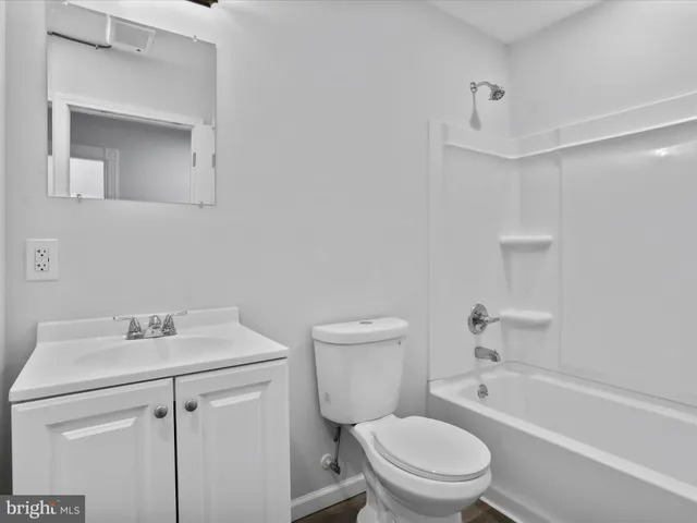 a bathroom with a sink toilet vanity and tub