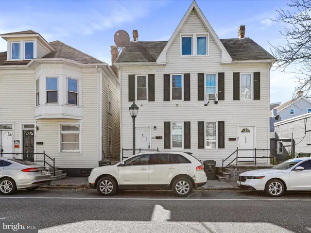 a car parked in front of a white house