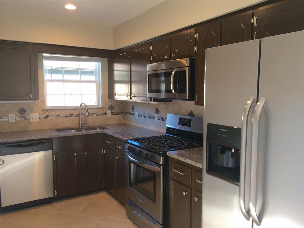 1416 Elms Road Irving, TX 75060 - Photo 3 of 7 a kitchen with granite countertop a refrigerator stove a sink and dishwasher with wooden floor