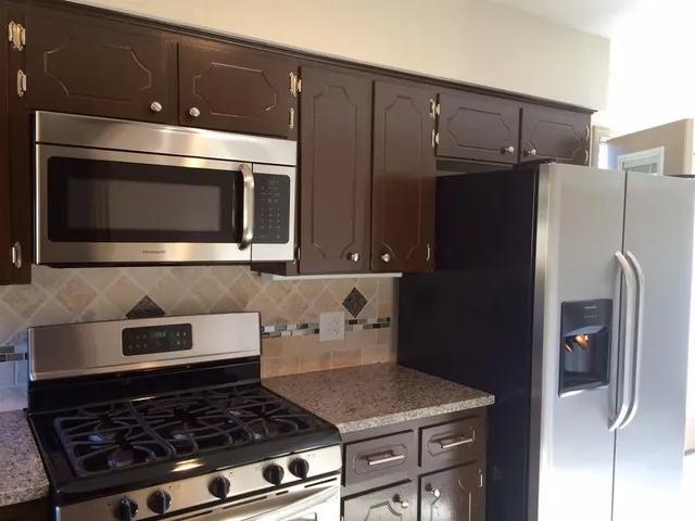 a kitchen with wooden cabinets and stainless steel appliances
