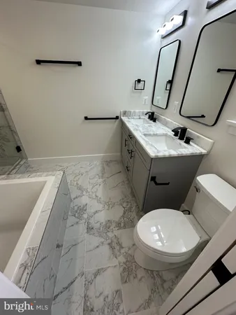 a white toilet sitting next to a bathroom sink
