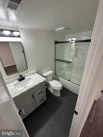a bathroom with a granite countertop sink a toilet and a mirror