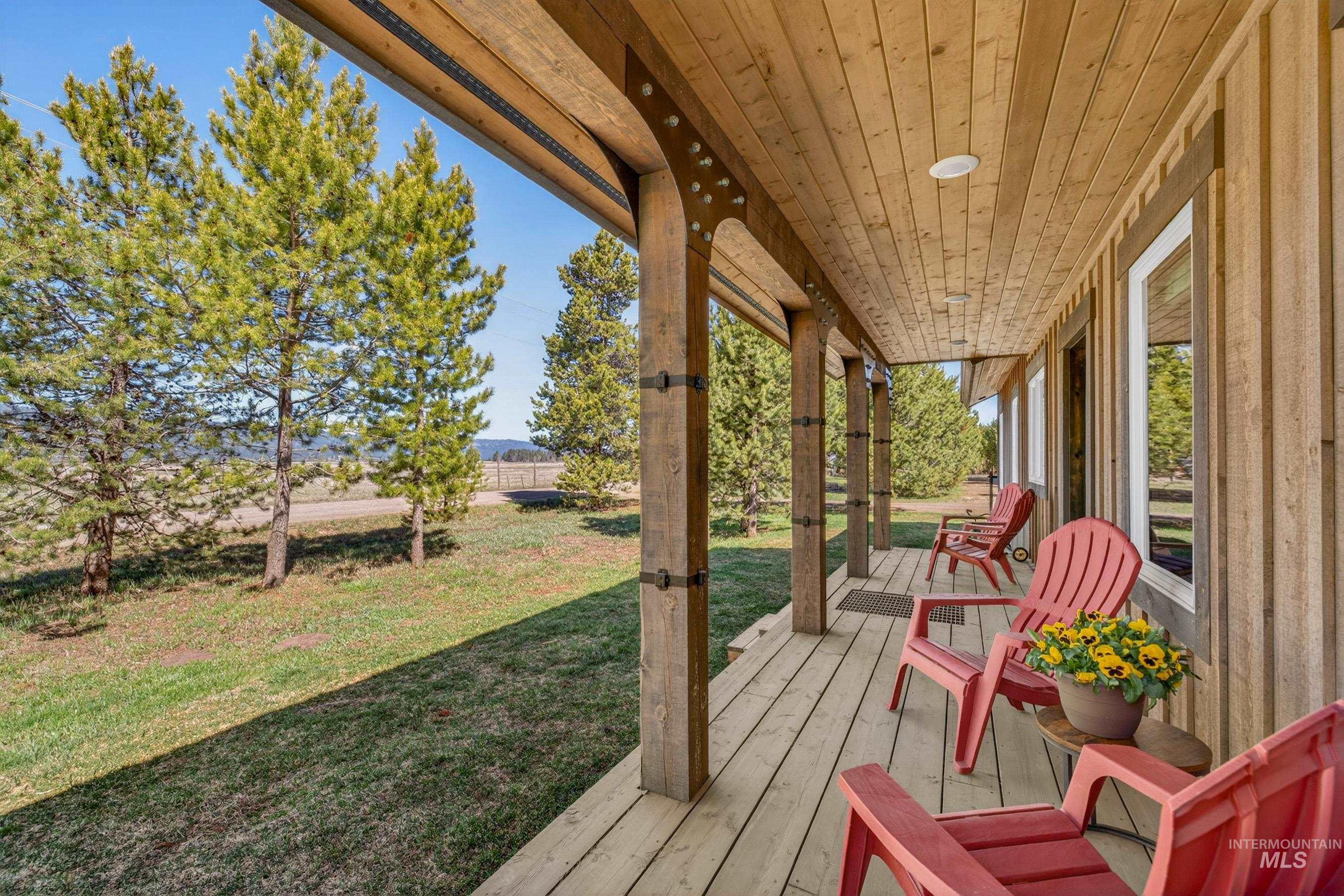 13388 Norwood Road McCall, ID 83638 - Photo 4 of 44 Expansive covered porch featuring wood plank flooring, exposed wood beams, a wood plank ceiling, and multiple windows
