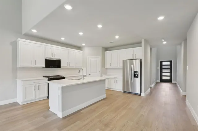 a kitchen with stainless steel appliances a refrigerator and a stove top oven