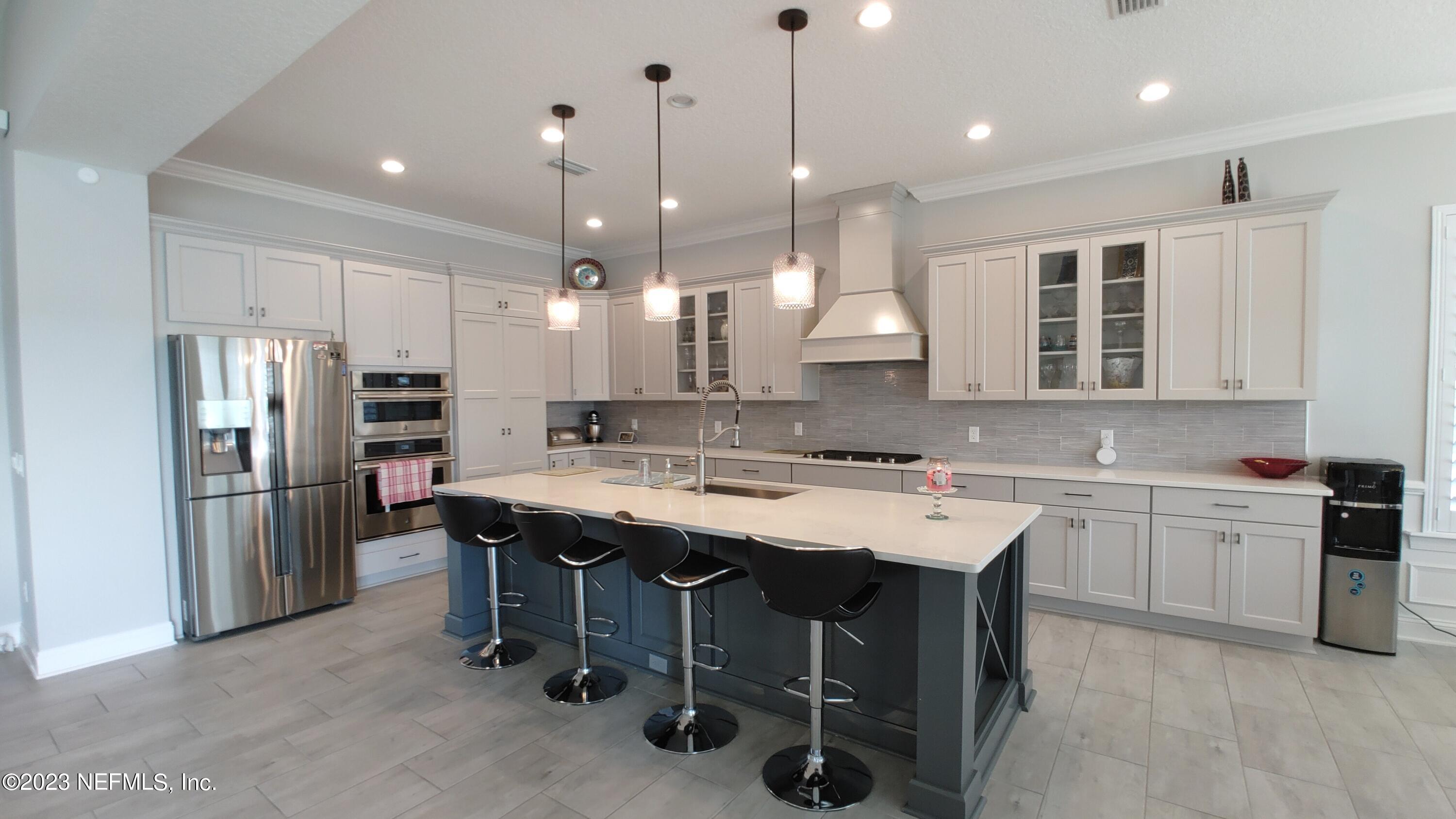 133 Pavati Point St. Johns, FL 32259 - Photo 11 of 46 a kitchen with a sink a center island stainless steel appliances and cabinets