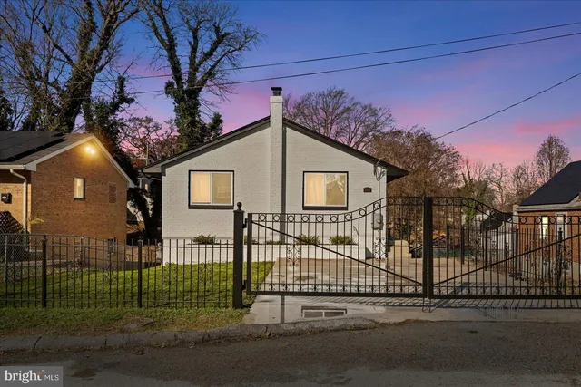 a view of a house with a small yard and fence