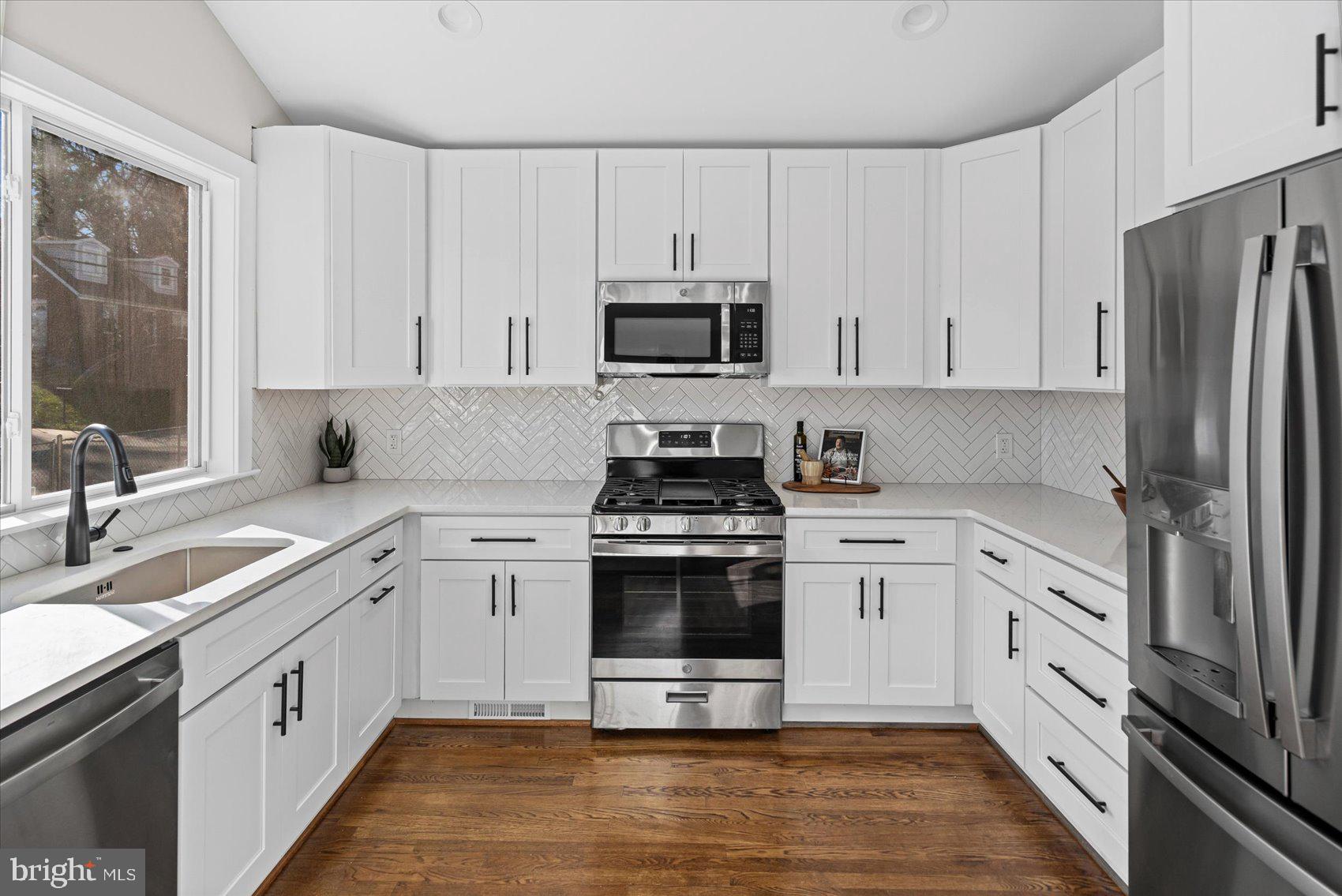 605 Elfin Avenue Capitol Heights, MD 20743 - Photo 11 of 42 a kitchen with cabinets stainless steel appliances a sink and a stove