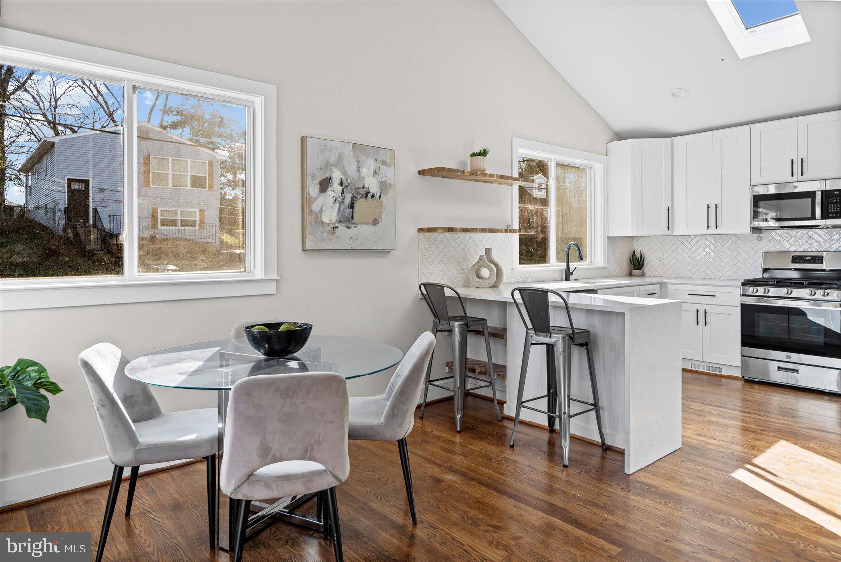 605 Elfin Avenue Capitol Heights, MD 20743 - Photo 13 of 42 a white kitchen with a dining table chairs and white appliances